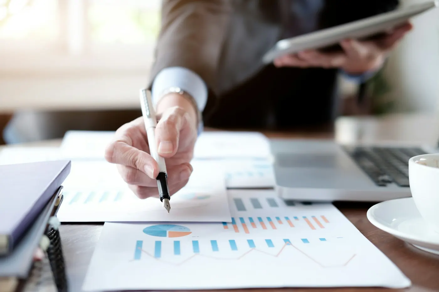 Investisseur analysant des graphiques financiers pour comparer la rentabilité d'immeubles à revenus