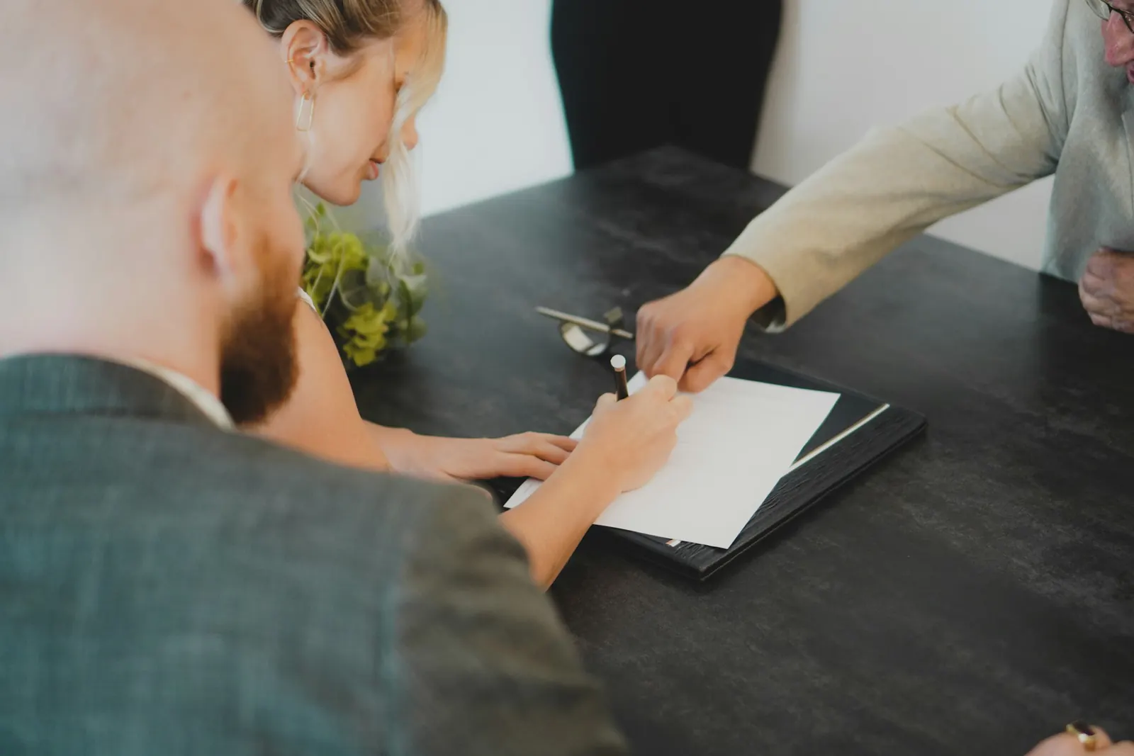 Gestionnaire immobilier accompagnant des locataires lors de la vérification de documents liés au bail