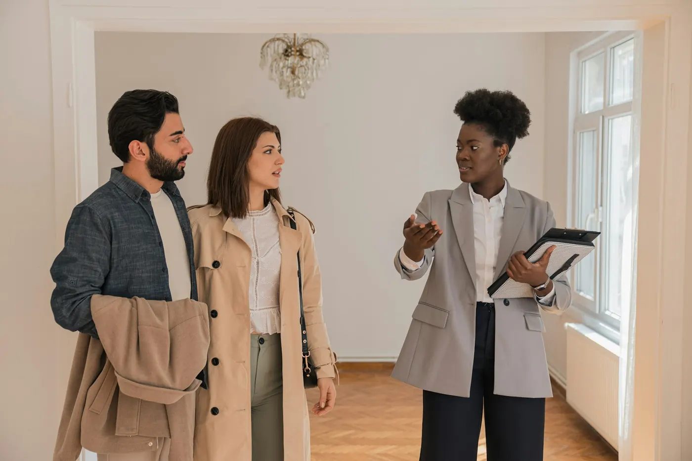 Investisseurs visitant un logement avec une professionnelle de l'immobilier pour évaluer un multilogement