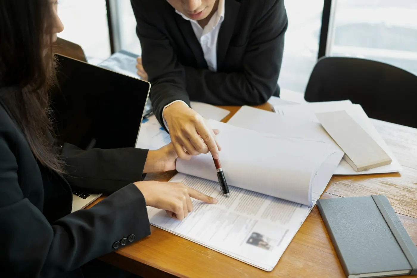 Professionnels examinant les obligations légales d'un propriétaire bailleur dans des documents