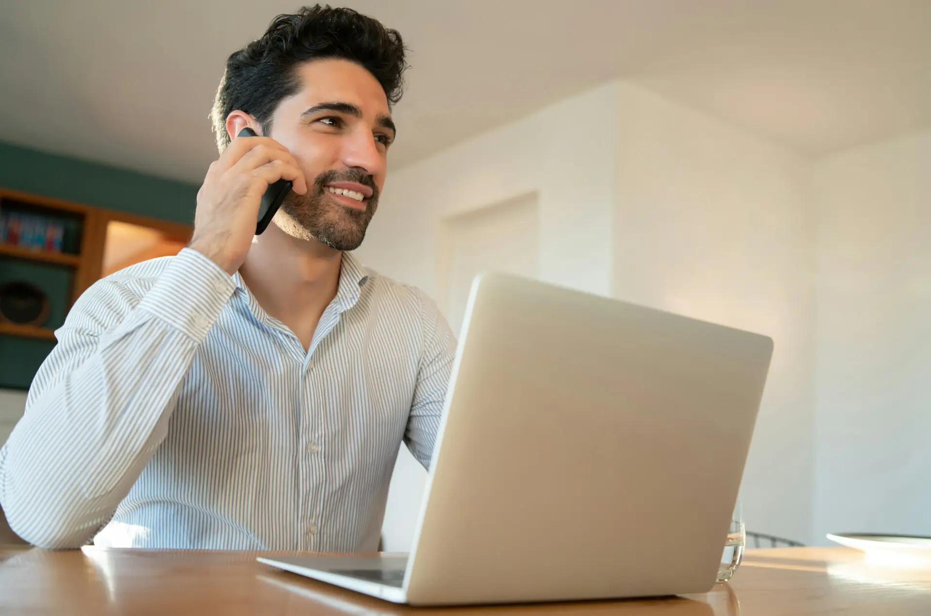 Gestionnaire immobilier à Repentigny au téléphone avec un propriétaire d'immeuble locatif, travaillant sur son ordinateur portable