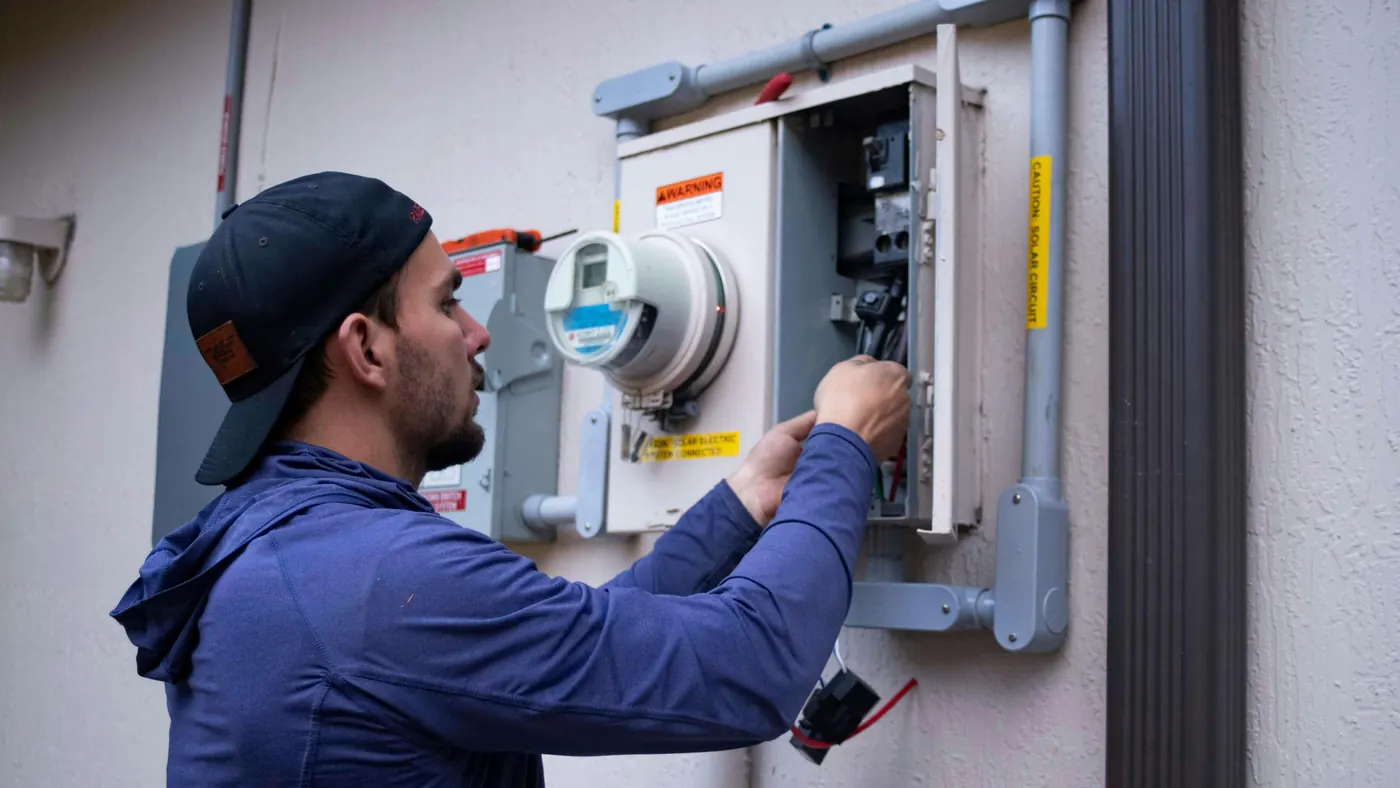 Technicien vérifiant l'installation électrique d'un immeuble locatif dans le cadre d'un entretien préventif